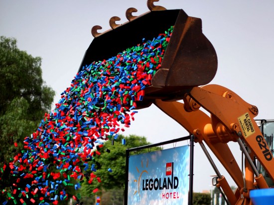 Een bulldozer dropt duizenden bouwsteentjes voor het Legoland-hotel